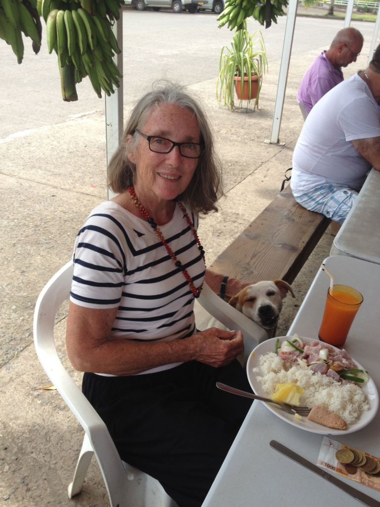18. This is a photo of Anne with a new friend from Nuku Hiva, un petite chien (a little dog), sharing the most popular food on Nuku Hiva, the delicious Poisson Cru au Lait de Coco (that's French for Raw fish with and coconut milk).  They also add fresh Nuku Hivan lime juice!