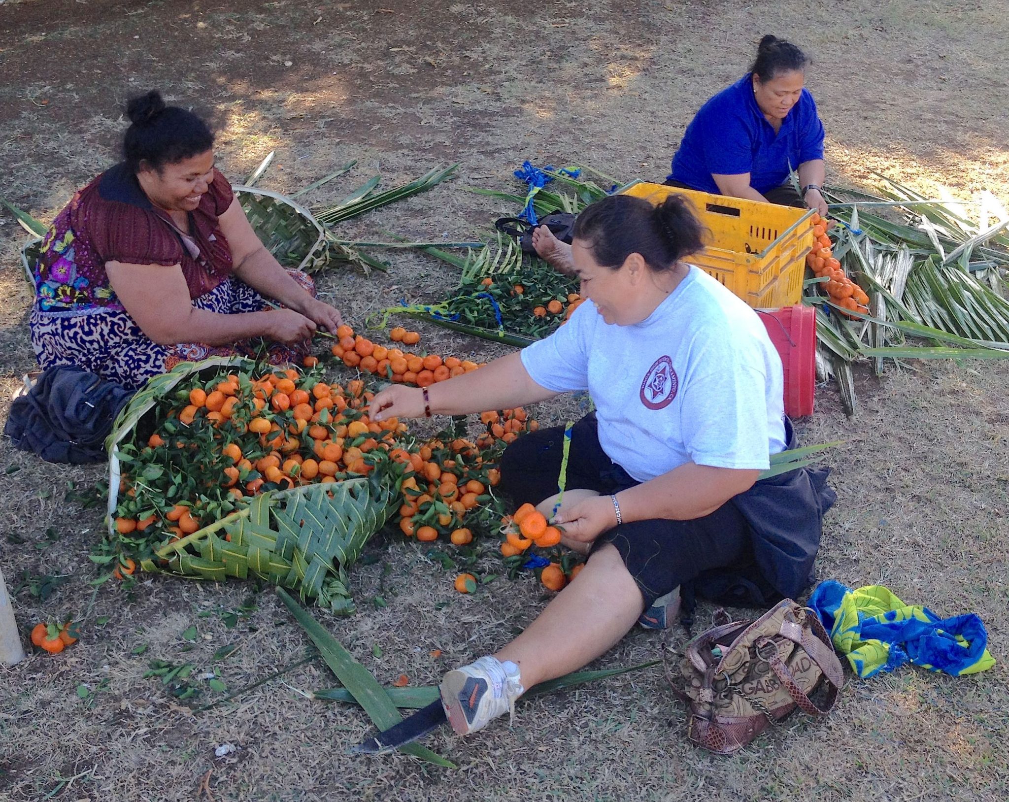 30. Ladies from Vava'u weaving wild tangerines together onto coconut leaves, ready to sell for the equivalant of $1.50 per string
